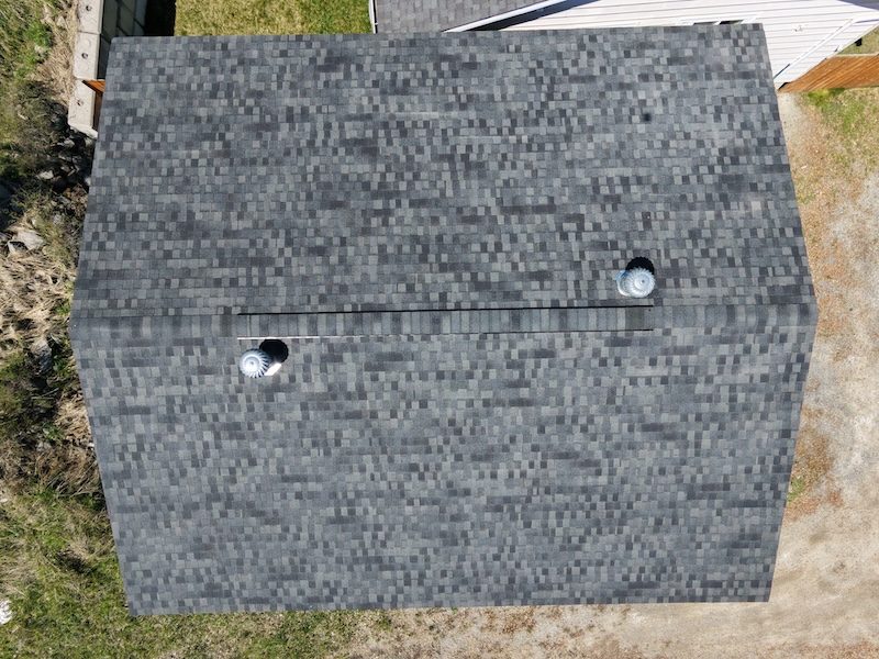 Overhead aerial shot of grey shingle roof with uniform NuRoof treatment