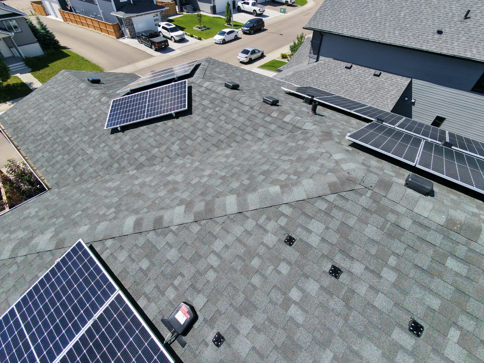 Aerial view of a shingle roof with solar panels treated with NuRoof