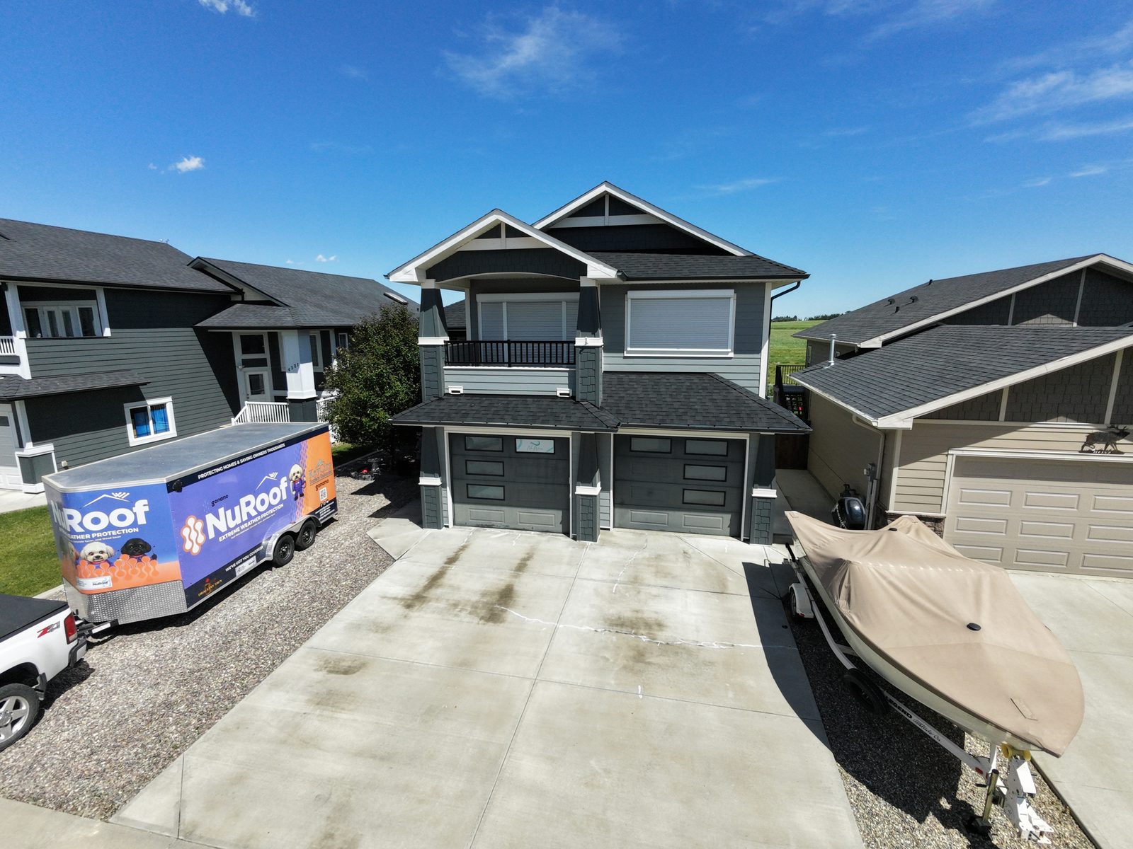 Completed NuRoof shingle protection on a two-storey home with the Key City trailer in the driveway