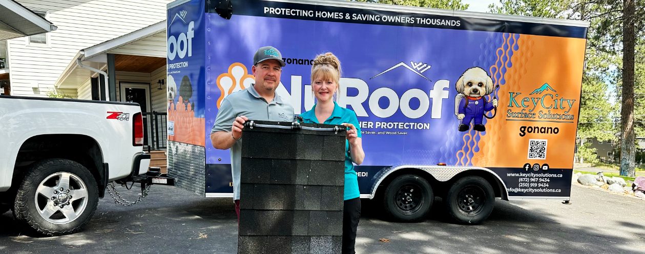 Jeff and Crystal Dyck standing in front of the NuRoof trailer, which reads "Protecting Homes & Saving Owners Thousands."
